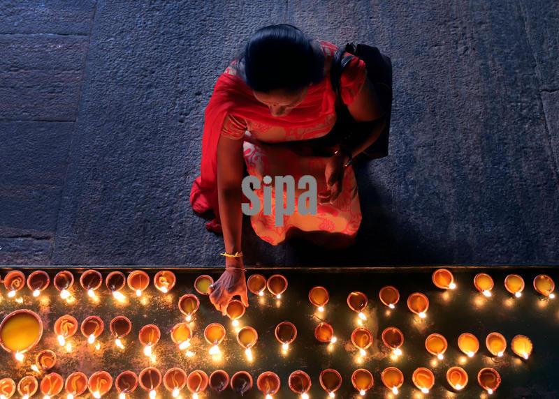 (251021) -- BEIJING, Oct. 21, 2025 (Xinhua) -- A woman lights oil lamps to celebrate Diwali, or the Hindu festival of lights, at a temple in Colombo, Sri Lanka, Oct. 20, 2025. (Photo by Ajith Perera/Xinhua) (Photo by Xinhua/Sipa USA)