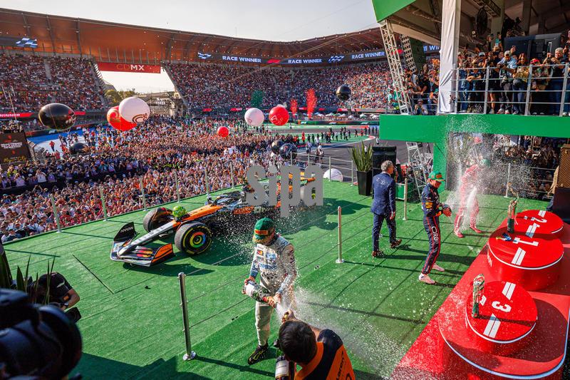 Race winner Lando Norris of Great Britain and McLaren Formula 1 Team (L), third place finisher Max Verstappen of the Netherlands and Oracle Red Bull Racing (C), and  second place finisher Charles Leclerc of Monaco and Scuderia Ferrari HP (R) celebrating by spraying champagne on the podium after the Formula 1 Mexico City Grand Prix at Autódromo Hermanos Rodríguez on October 26, 2025 in Mexico City, Mexico. (Photo by Ben Adams/Sipa USA)