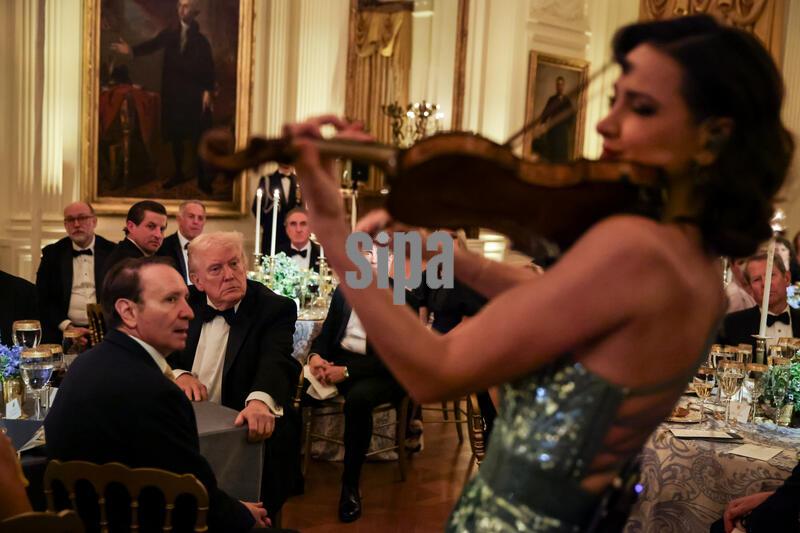 U.S. President Donald Trump watches as Moldovan violinist Rusanda Panfili performs during the Governors Dinner in the East Room of the White House on February 21, 2025 in Washington, D.C. (Photo by Samuel Corum/Sipa USA)