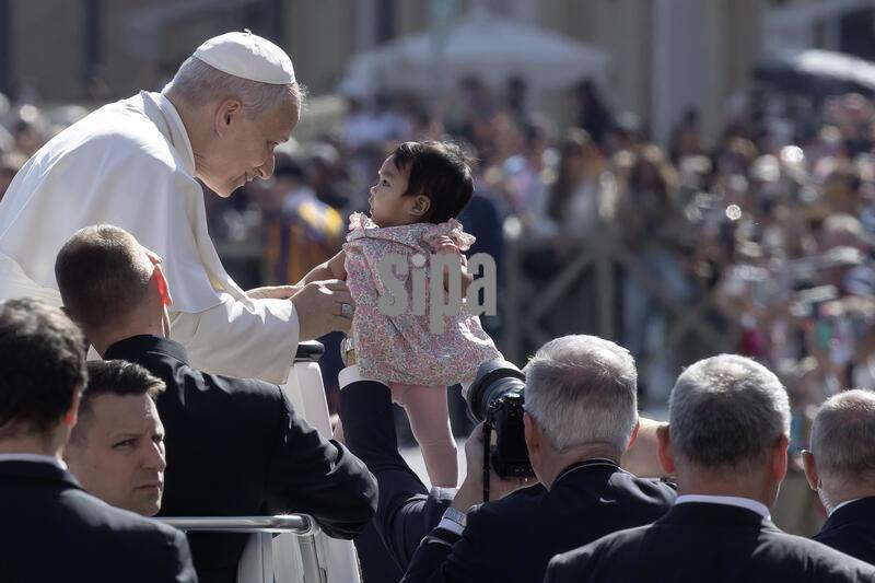 Pope Leo XIV greets a child as he arrives for  his weekly general audience in St. Peter's square at the Vatican. (Photo by Maria Grazia Picciarella / SOPA Images/Sipa USA)