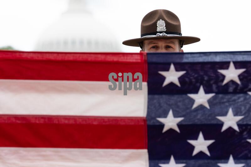 An Illinois State Police honor guard practices a flag folding ceremony during National Police Week on the National Mall in Washington D.C., on Thursday, May 14, 2026.