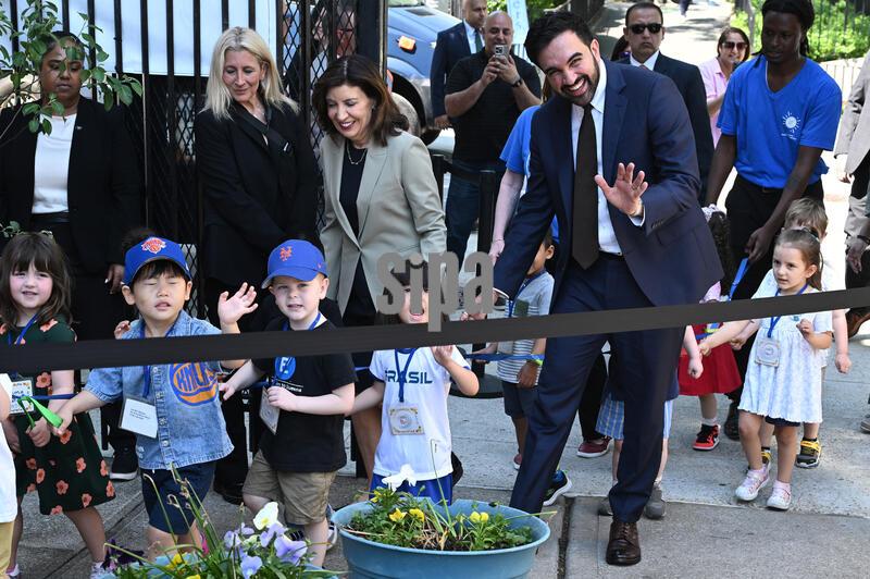 Holding a walking rope, Gov. Kathy Hochul (3-l) and Mayor Zohran Mamdani (r) arrive with a group of kindergarten children at a press conference to announce an additional 99,921 offers for 3-K and Pre-K in Queens borough, New York, NY, May 19, 2026. Joined by Schools Chancellor Kamar Samuels (not in picture), it was also announced that travel distance for 3-K families will be reduced by six blocks. [Editor's Note: Names of children on their tags have been digitally blurred in post-production to protect their identities.](Photo by Anthony Behar/SipaUSA) 