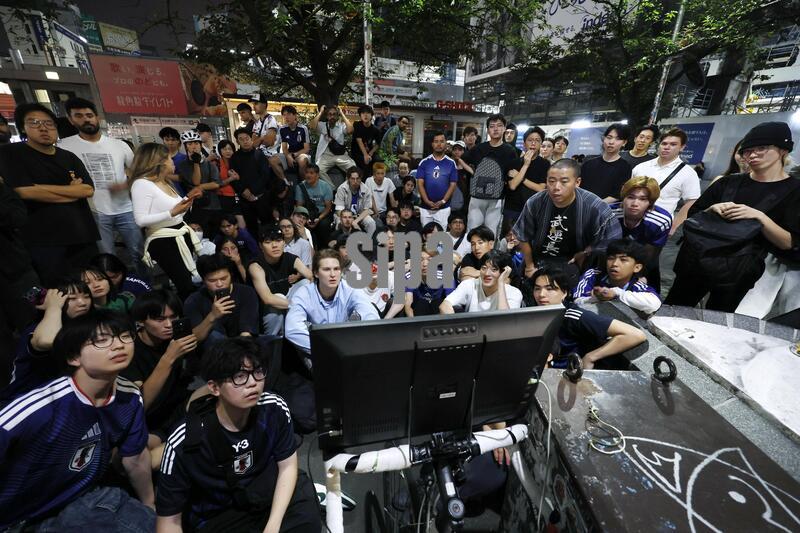 Japan supporters gather around a television on a street in Tokyo's Shibuya area in the small hours of June 30, 2026, to watch a World Cup round of 32 football match between Japan and Brazil in Houston. (Photo by Kyodo News/Sipa USA)
