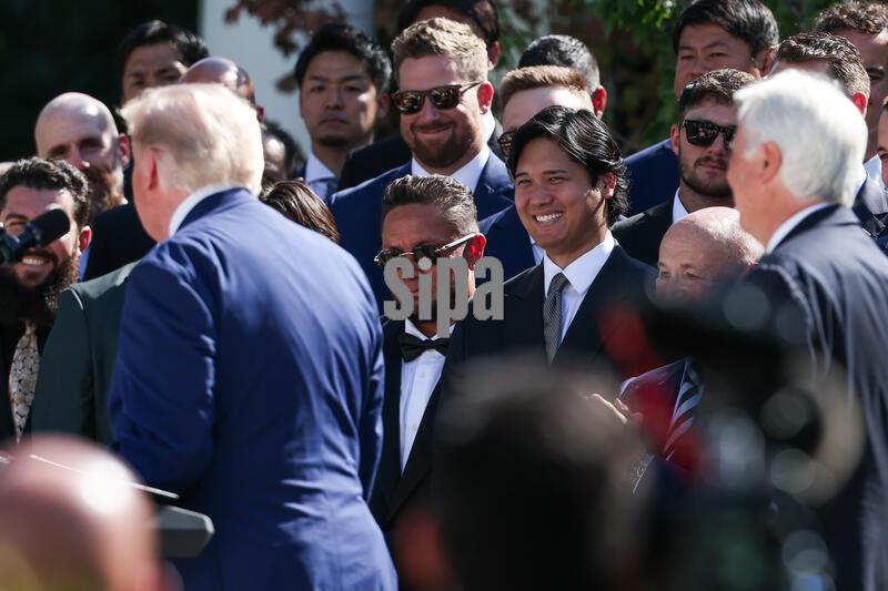 Miguel Rojas and Shohei Ohtani listen to President Donald Trump during an event with the 2025 MLB World Series Champions the Los Angeles Dodgers in the Rose Garden at the White House on July 23, 2026 in Washington, D.C. The Dodgers defeated the Toronto Blue Jays in Game 7 of the 2025 MLB World Series to claim back-to-back championship titles. (Photo by Samuel Corum/Sipa USA)