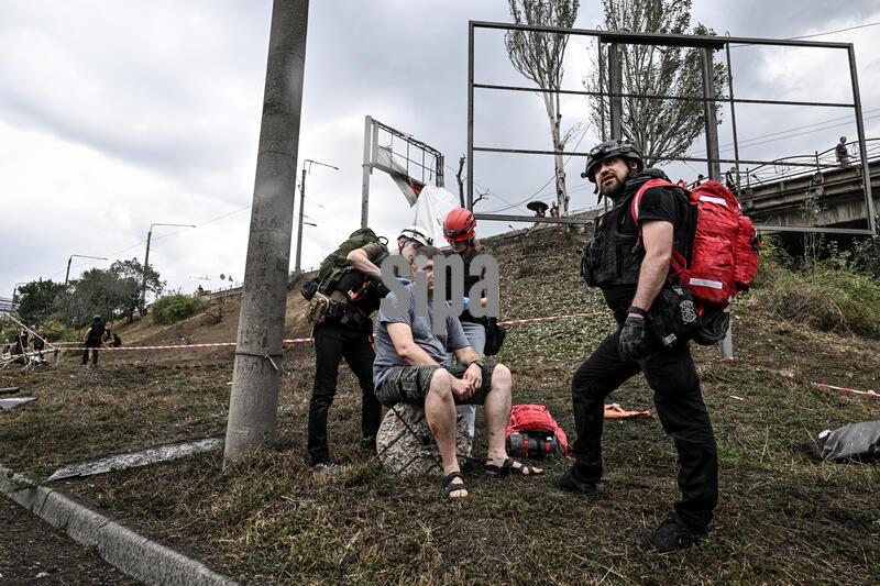 Volunteer paramedics administer first aid to a driver who was injured in a Russian air strike, Zaporizhzhia, Ukraine, July 23, 2026. In the evening, Russian occupying forces carried out a massive air raid on the southeastern Ukrainian city, launching five guided aerial bombs on residential districts and the industrial zone. Civilian infrastructure was damaged, including apartment blocks, a supermarket, cars and a private medical centre. At least 18 people were injured in the terrorist attack, among them a child who is in serious condition. (Photo by Dmytro Smolienko/Ukrinform) (Photo by Ukrinform/Ukrinform/Sipa USA)