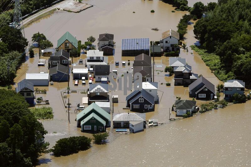 Photo taken from a Kyodo News helicopter shows a residential area submerged in floodwater in Oamishirasato in Chiba Prefecture, east of Tokyo, on Aug. 14, 2026, after torrential rain overnight. (Photo by Kyodo News/Sipa USA)

