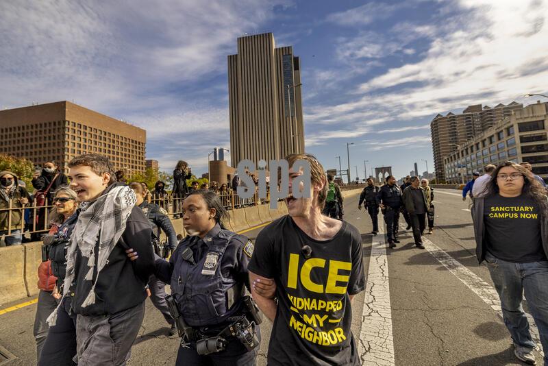 NEW YORK, NEW YORK - OCTOBER 28: A coalition of groups participates in a civil disobedience action against Immigration and Customs Enforcement (ICE), blocking the Manhattan side of the Brooklyn Bridge on October 28, 2026, in New York City. New Yorkers continue to take the streets after an ICE agent shot a 28-year-old man, Oscar Belgal, during an attempted arrest in the Marble Hill neighborhood of the Bronx earlier this month.(Photo by Michael Nigro/Sipa USA)