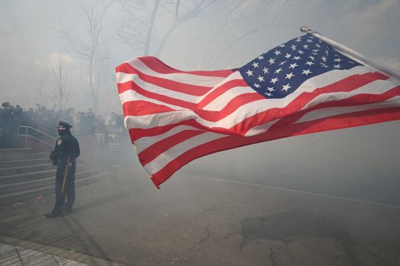 Celebrating the 'Year of the Snake', an NYPD officer looks on as smoke from firecrackers envelops crowds attending the 27th New Year Firecracker Ceremonies during Chinese Lunar New Year Celebrations